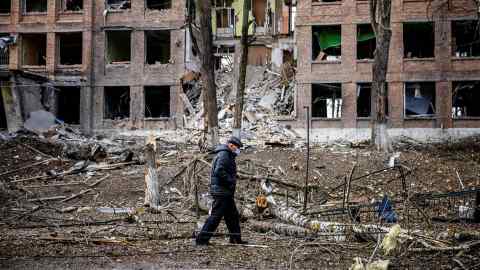 A man walks in front of a destroyed building after a Russian missile attack in the town of  Vasylkiv, near Kyiv, on February 27, 2022