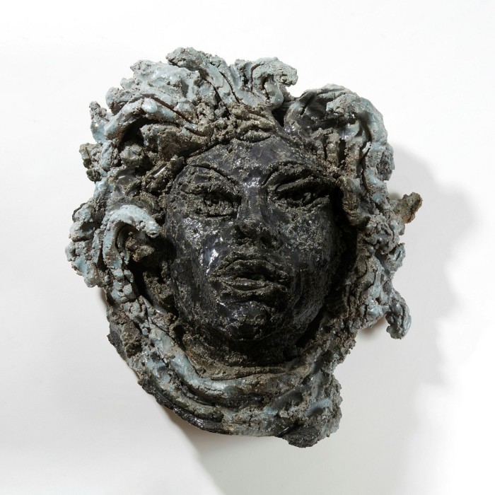 A ceramic mask of a woman with serpentine hair