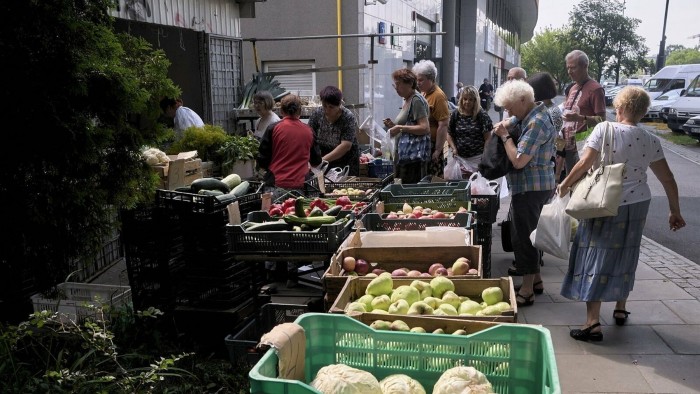 Customers at a fruit and vegetable store in Warsaw
