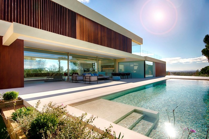A Modernist home with flat roofs, panoramic glass windows, infinity pool and sweeping views