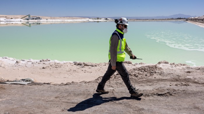 A lithium mine supervisor inspects an evaporation pond