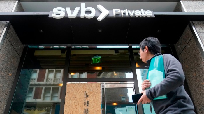 A pedestrian passes a Silicon Valley Bank branch in San Francisco, US