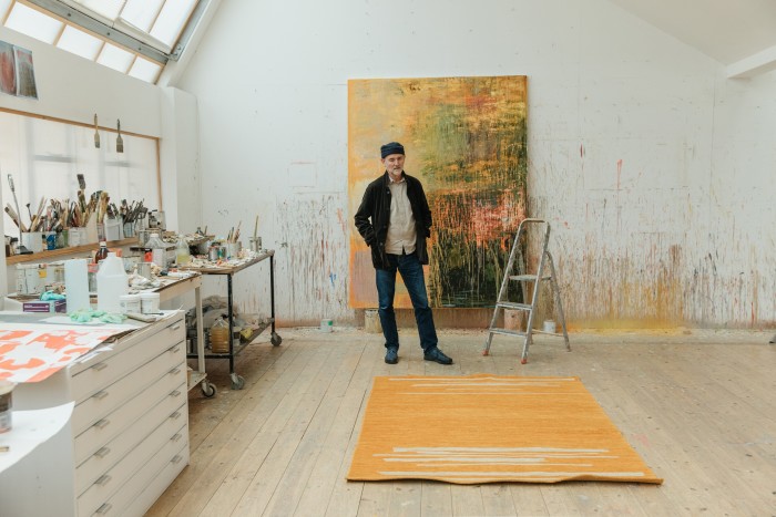 Christopher in his studio. On the floor is the rug Courts and Fields VI. In the background is one of his works in progress
