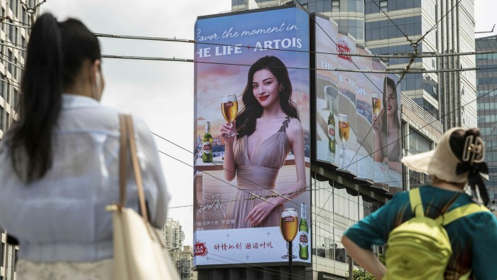 People look at a billboard advertising beer in Shanghai. Having spent four decades creating one of the most unequal societies on Earth, Beijing is now seized by a mantra of ‘common prosperity’