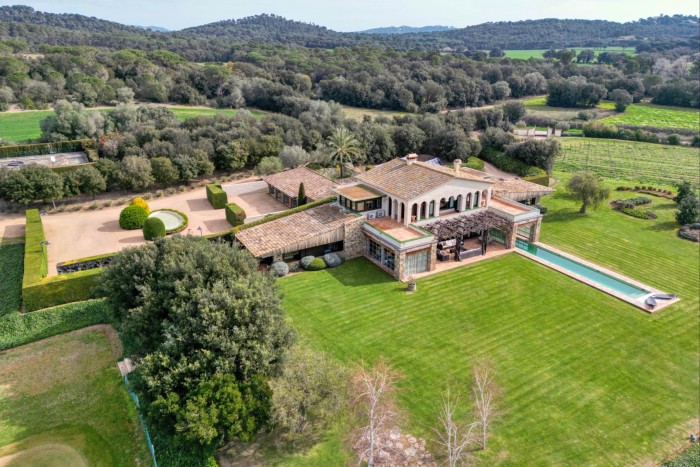 An aerial shot of the villa with loggia on second floor, pergola and long swimming pool both undercover and outside, all set in extensive lawn grounds