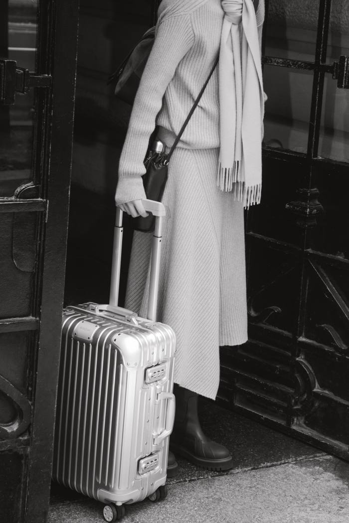 Loro Piana cashmere jumper, £1,535, cashmere scarf, £450, matching skirt, £1,895, and leather and cashmere Storm System ankle boots, £1,355. Lemaire leather water-bottle carrier, £495. Rimowa aluminium silver Original Cabin case, £1,020