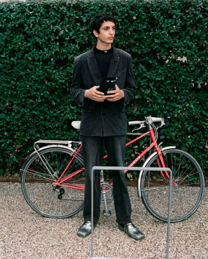 Tak Bengana wears vintage jersey worn-out slim jacket, £1,550. Technical-jersey fitted top, £350. Vintage jersey worn-out slim pants, £825. Embroidered-cotton destroyed piercing cap, £350. Chevalier Derby shoes, £1,890. All Balenciaga