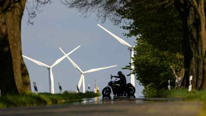 Wind turbines beyond a motorcyclist in Brandenburg, Germany, on Monday, May 2 2022