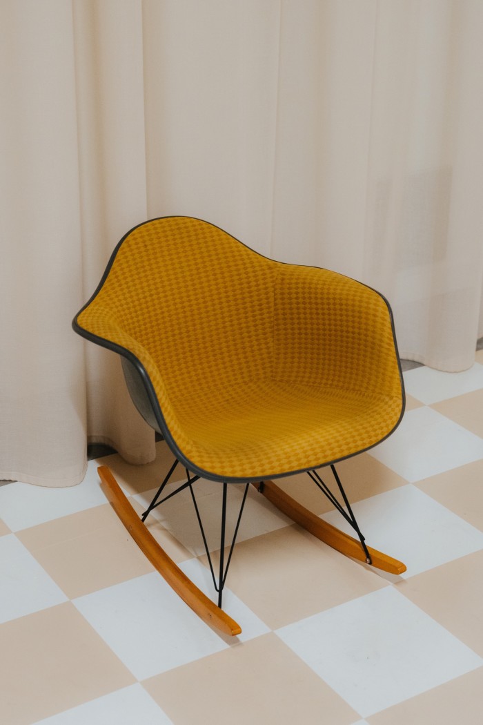 An Eames upholstered moulded plastic armchair with a rocker base