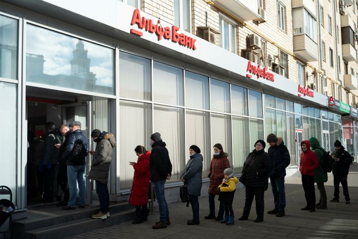 People queue to withdraw money from an ATM in Moscow last weekend as the rouble went into freefall following western sanctions on Russia