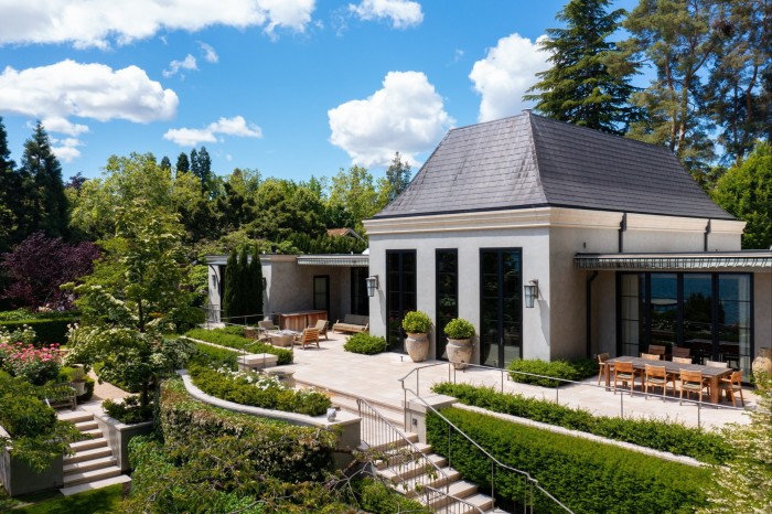 The exterior of a white house and limestone terrace overlooking a pretty garden in Madison Park, Seattle, $25mn