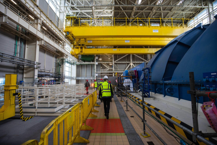 A worker walks near the turbine deck and generator at the third-generation European Pressurised Reactor project (EPR) nuclear reactor