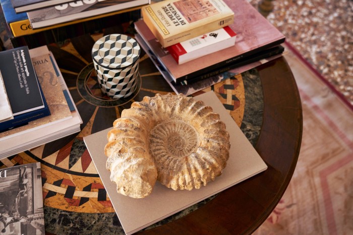 A nautilus fossil and books on an Italian neoclassical table