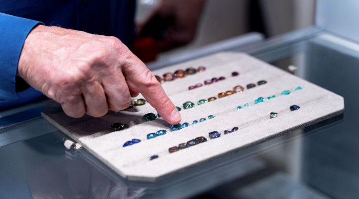 a finger pointing at an item in a gem collection