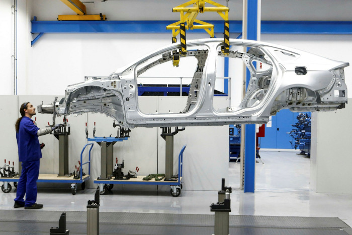 An employee prepares a Ford Mondeo body for quality control checks at the Ford plant in Valencia