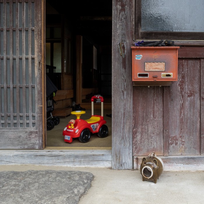 A child’s plastic ride-on car seen through a doorway