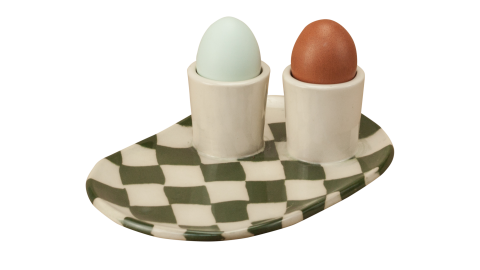two eggs placed on an egg cup plate with a  checkerboard pattern