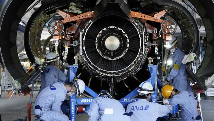 Technical staff members perform maintenance work to an engine for an Airbus SE A321 aircraft