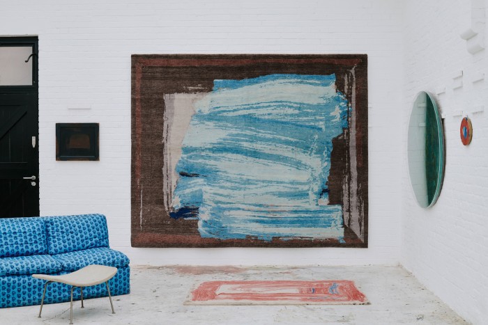 Christopher Farr hand-knotted Indian Sea rug (on wall), £18,000, and Christopher Farr EDITIONS hand-tufted Red Sky In The Morning rug (on floor), £1,920, both produced in association with the estate of Howard Hodgkin, available from Gagosian Gallery