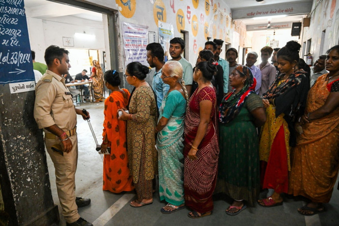 Voters queue at a polling station during the third phase of voting for national elections in Ahmedabad, Gujarat, earlier this month