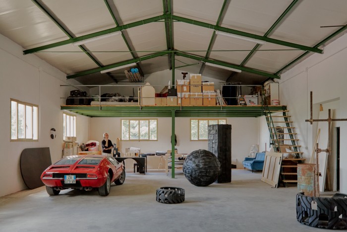 The studio contains tyre sculptures by the artist and a De Tomaso supercar