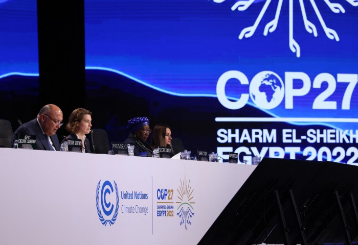 A panel of four people, headed by Egypt’s foreign minister Sameh Shukri at left, look out at the audience during the closing session of the COP27 climate conference