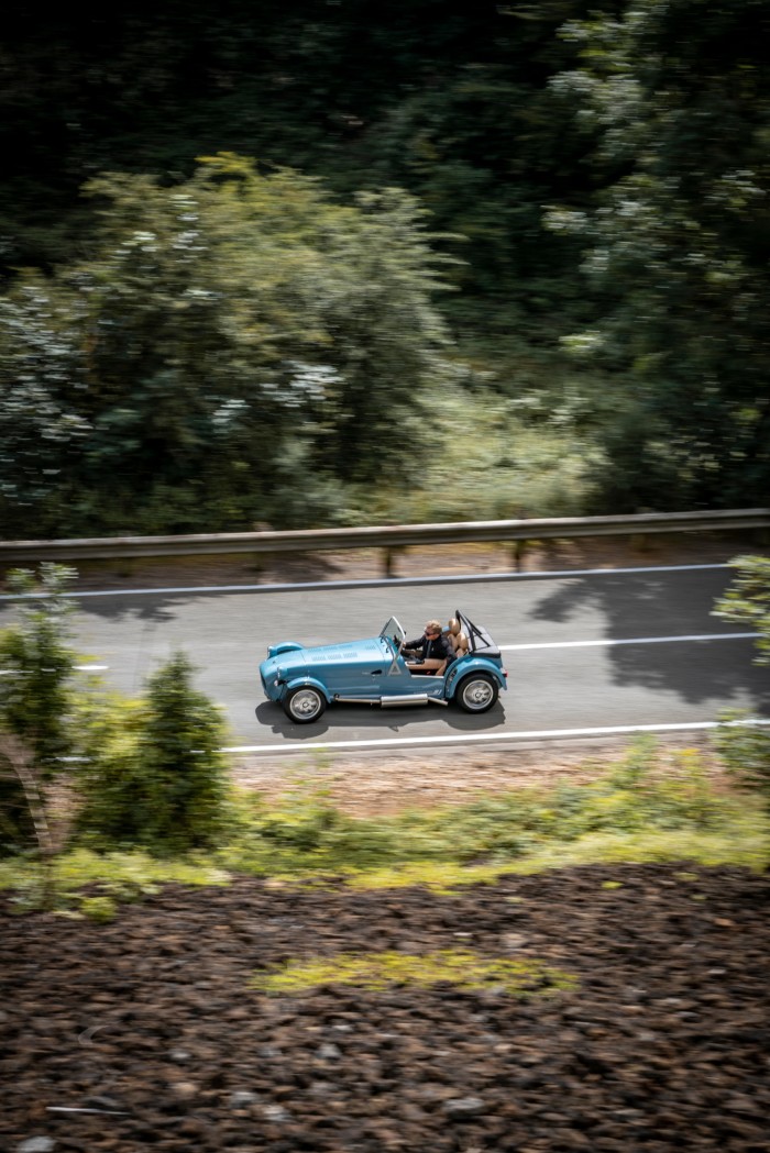 A blue Caterham Seven takes to the road