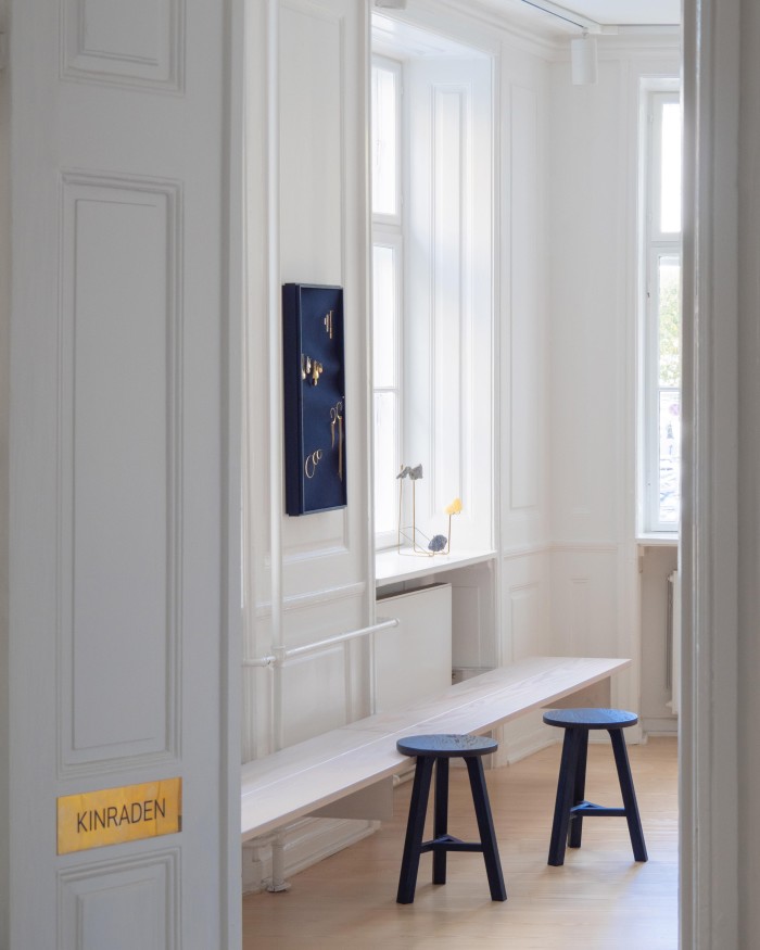 Kinraden’s Copenhagen boutique,: blue stools sit against a shelf displaying jewellery pieces