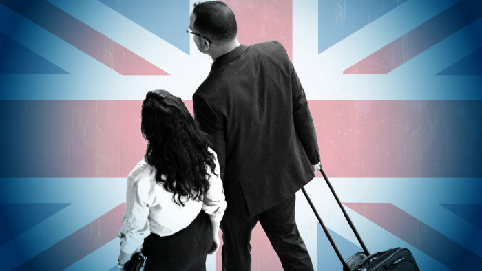 Couple with suitcases against a Union flag