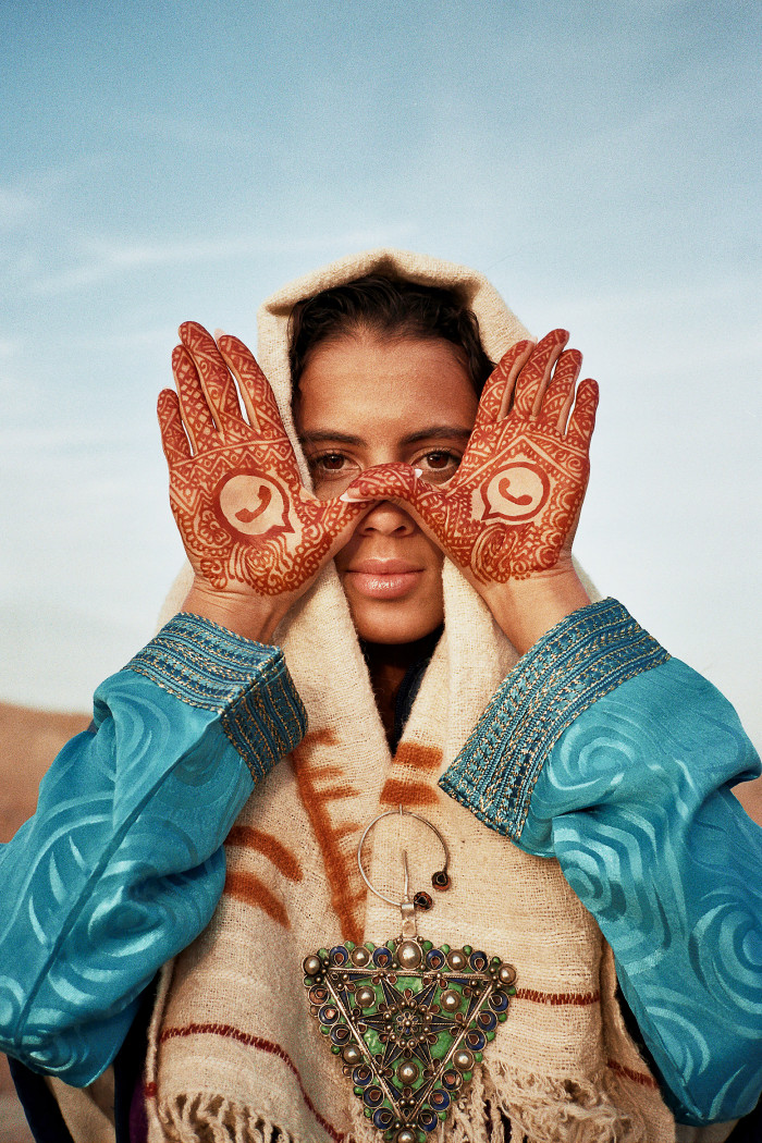 Lamrabat’s portrait of Rania, her palms decorated with henna WhatsApp logos