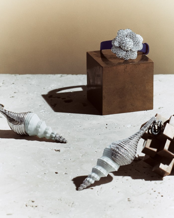 From top: Van Cleef & Arpels white-gold and diamond Cosmos secret watch (closed), with navy grosgrain strap. Boucheron white-gold, diamond, mother-of-pearl and shell Coquillage Diamant earrings