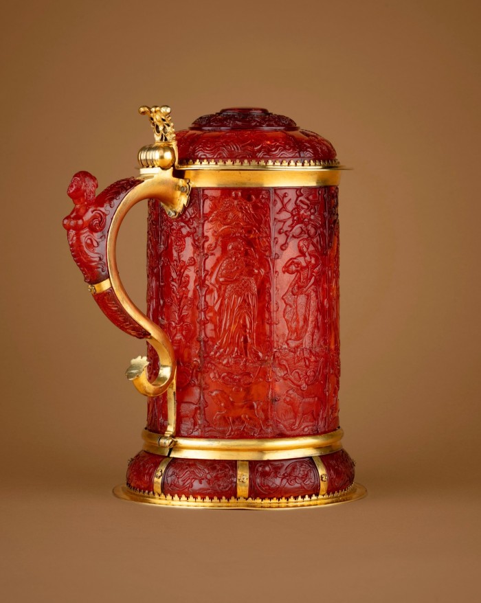The tankard is made of elaborately carved amber and has gold fittings