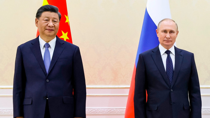 Xi Jinping and Vladimir Putin in front of their national flags