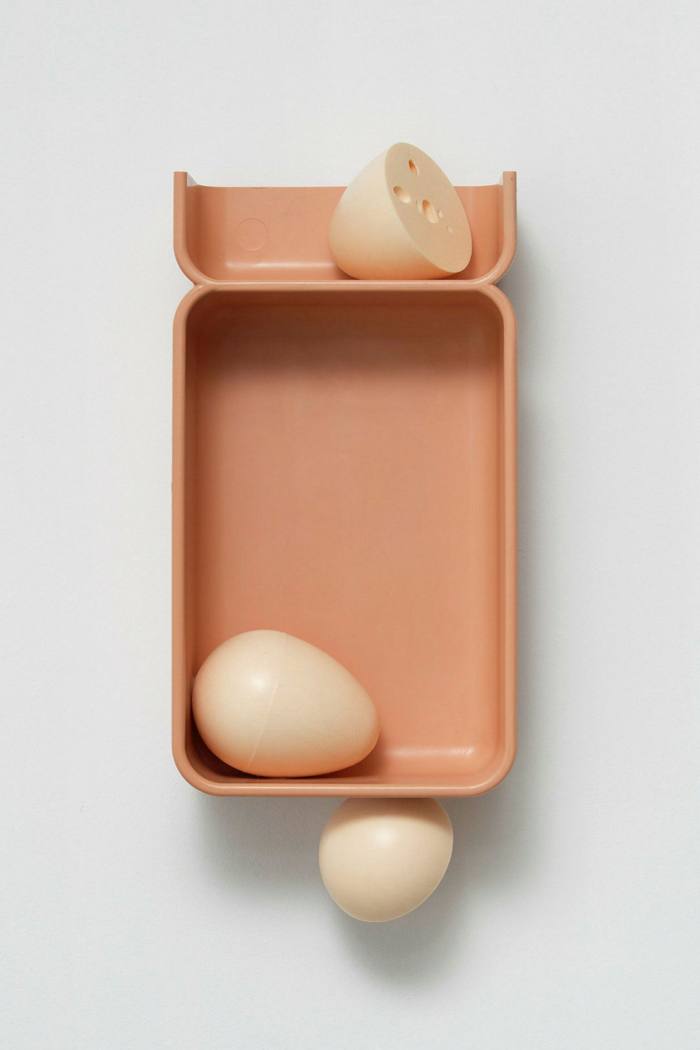 A pale pink box with large fake eggs