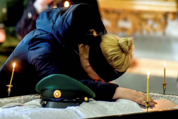 The mother of 20-year-old Russian serviceman Nikita Avrov, grieves over his coffin during his funeral service