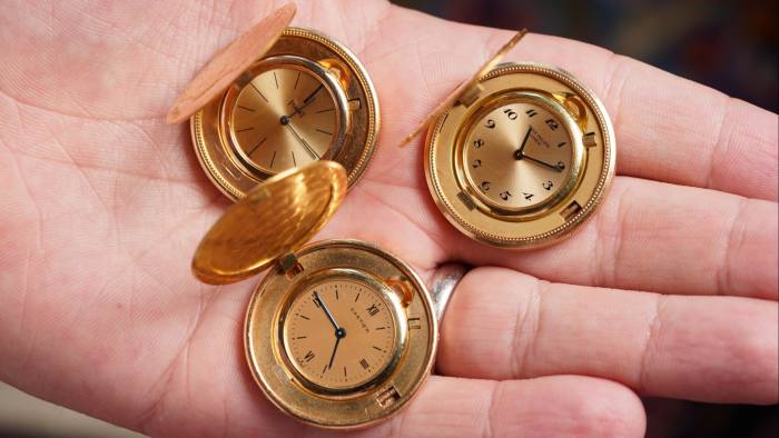 Three coin watches on the palm of a left hand