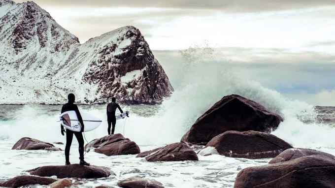 Devi Kroell (left) and her coach head for the surf in Lofoten