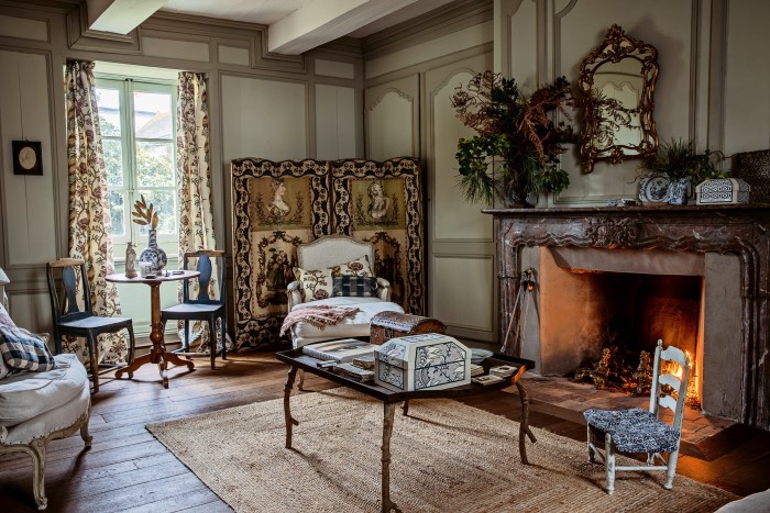 The living room, with a bespoke table by José Esteves, Louis XV-style Bergère chair and an 18th-century screen covered in domino paper and gouache prints