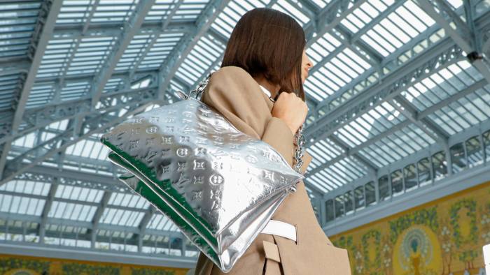 A model carries a luxury handbag during the Louis Vuitton fashion show in Paris in 2021