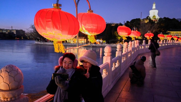 Visitors take pictures next to lanterns at a park in Beijing
