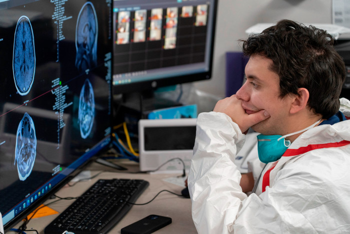 A medic watches a screen which shows a patient’s MRI images
