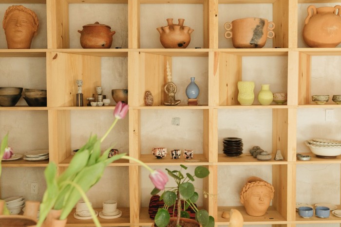 Shelves display work by Raina Lee, Perla Valtierra, Philip Kupferschmidt and others. 