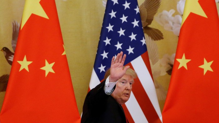 Donald Trump waves in front of US and China flags