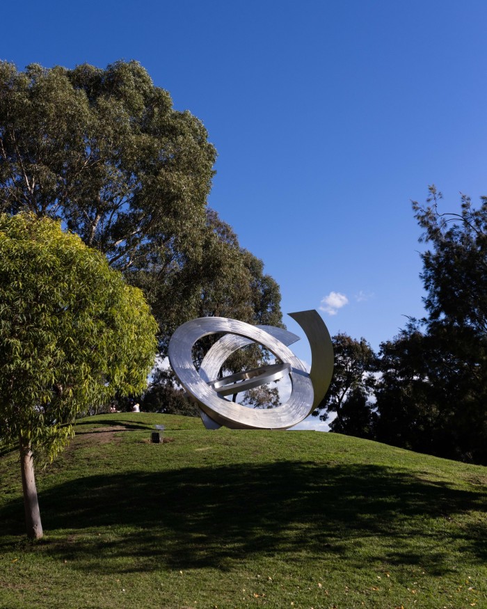 A large sculpture of interlinking circles on a lawn at Heide Museum of Modern Art