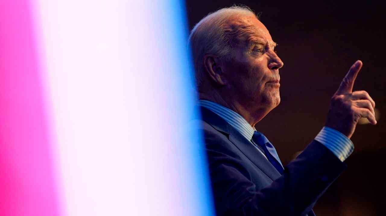 Side view of Joe Biden on stage talking and pointing with his right hand