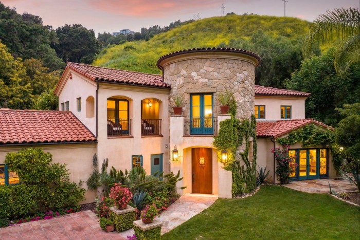 A Spanish-style house with a tower at its entrance, surrounded by lush planting, $4.995mn