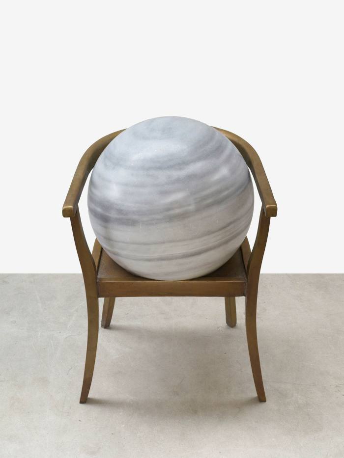 What looks like a large bowling bowl sits on stylish wooden chair