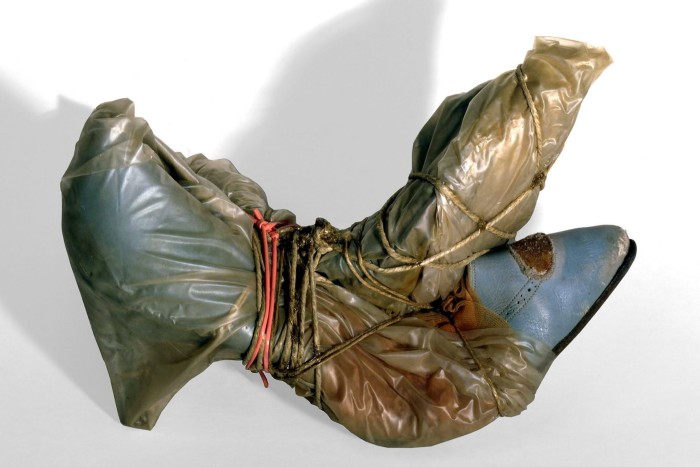 A pair of blue shoes wrapped in plastic and secured by red rubber bands