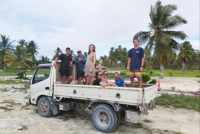 Tourists on a flatbed truck going through scrubland