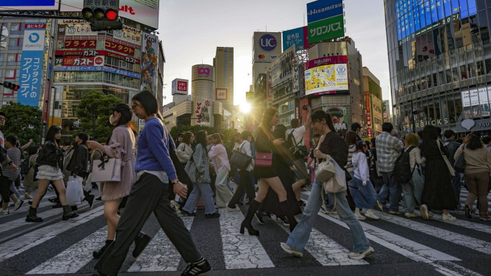 Pedestrians cross an intersection in the Shibuya district of Tokyo